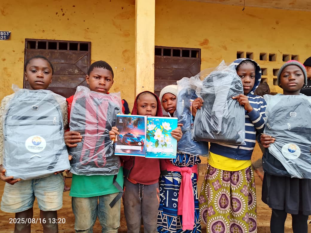 Children proudly displaying their school bags and educational materials